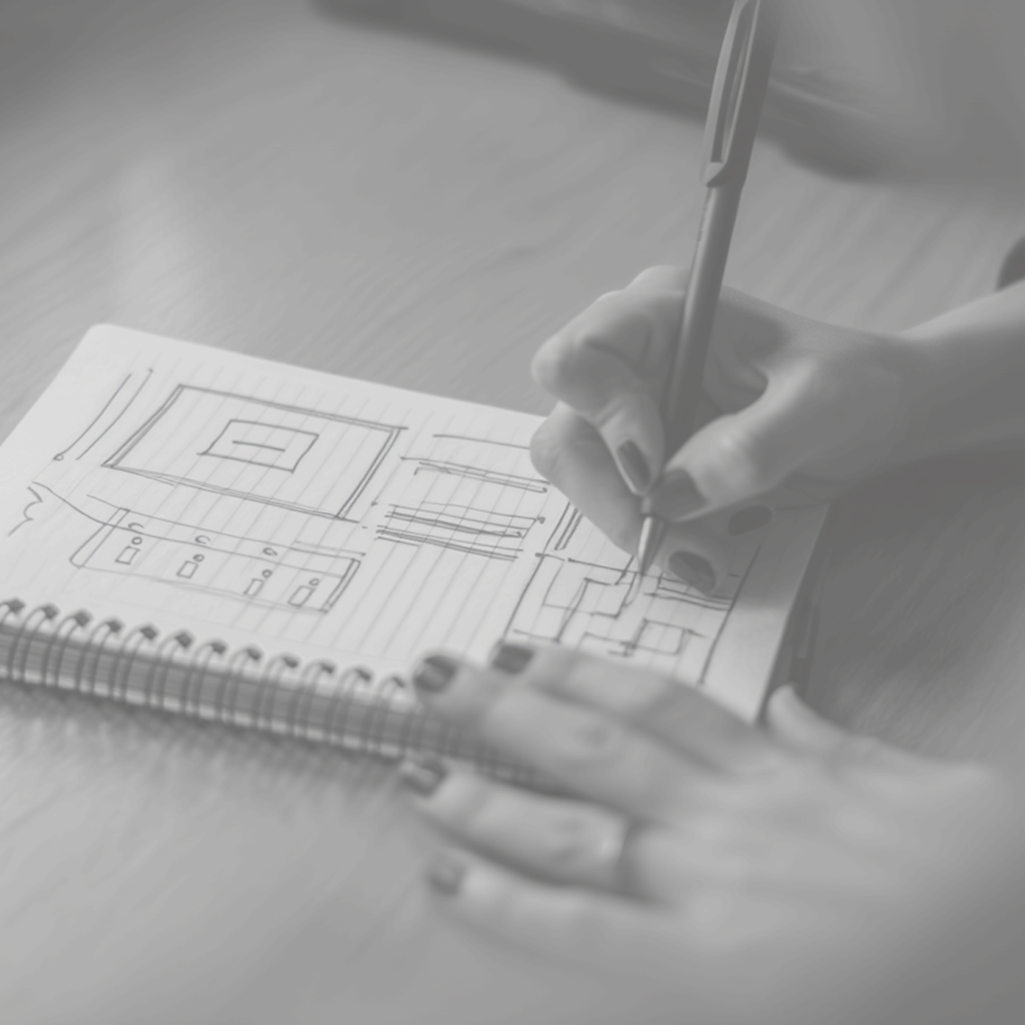 Manos escribiendo en una pizarra con esquemas y notas sobre diseño y procesos.